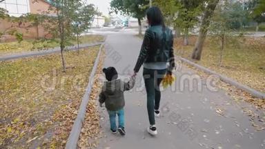 年轻的母亲和一个小儿子在秋天公园散步。 秋天公园的<strong>幸福</strong>家庭。 自然概念中的<strong>幸福</strong>家庭。 4K